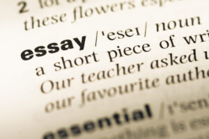 Close up of English dictionary page with the word essay and its definition